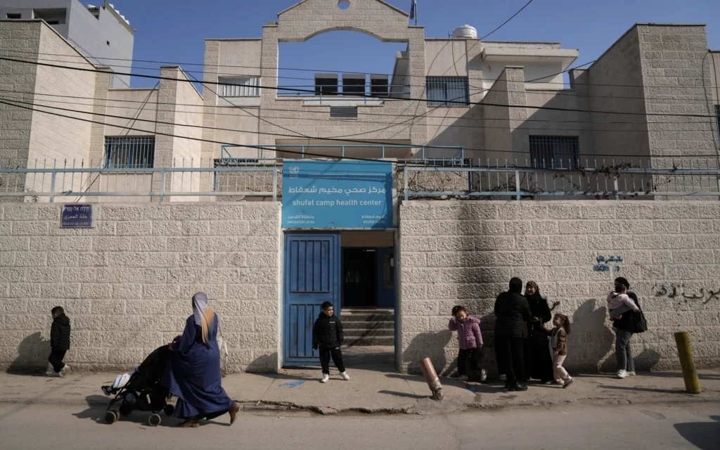 Des Palestiniens se rassemblent devant une clinique gérée par l'agence des Nations Unies pour les réfugiés palestiniens, connue sous le nom d'UNRWA, dans le camp de réfugiés de Shuafat à Jérusalem, lundi 27 janvier 2025. (Crédit : AP Photo/Mahmoud Illean) Des Palestiniens se rassemblent devant une clinique gérée par l'agence des Nations Unies pour les réfugiés palestiniens, connue sous le nom d'UNRWA, dans le camp de réfugiés de Shuafat à Jérusalem, lundi 27 janvier 2025. (Crédit : AP Photo/Mahmoud Illean)