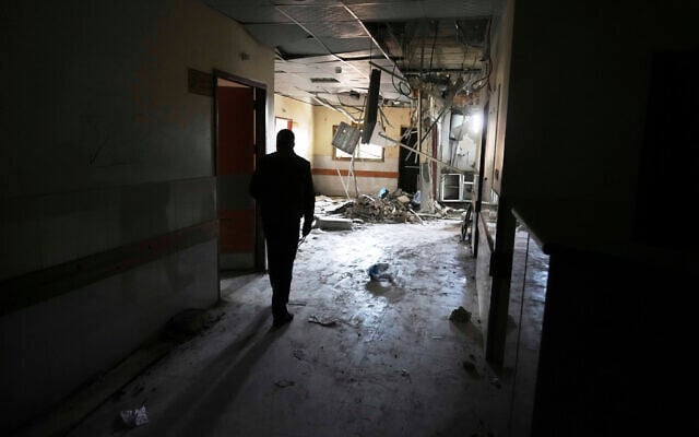 Photo d'illustration : Le docteur Marwan al-Hams, directeur du département des hôpitaux de campagne à Gaza, examine les destructions à l'intérieur d'un bâtiment de l'hôpital Nasser au lendemain d'une frappe aérienne israélienne à Khan Younès, dans la bande de Gaza, le 24 mars 2025. (Crédit : AP/Abdel Kareem Hana)