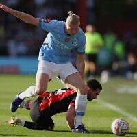 Le footballeur norvégien Erling Haaland (en haut), qui joue pour Manchester City, tente de récupérer le ballon face à Lewis Cook, de Bournemouth, lors du quart de finale de la Coupe d'Angleterre entre Bournemouth et Manchester City, au stade Vitality de Bournemouth, en Angleterre, le 30 mars 2025. (Crédit : Ian Walton/AP)