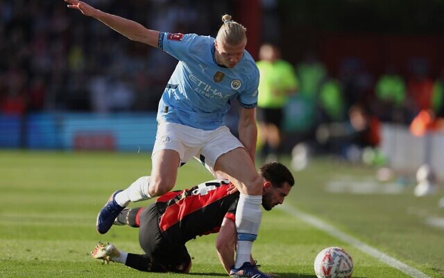 Le footballeur norvégien Erling Haaland (en haut), qui joue pour Manchester City, tente de récupérer le ballon face à Lewis Cook, de Bournemouth, lors du quart de finale de la Coupe d'Angleterre entre Bournemouth et Manchester City, au stade Vitality de Bournemouth, en Angleterre, le 30 mars 2025. (Crédit : Ian Walton/AP) Le footballeur norvégien Erling Haaland (en haut), qui joue pour Manchester City, tente de récupérer le ballon face à Lewis Cook, de Bournemouth, lors du quart de finale de la Coupe d'Angleterre entre Bournemouth et Manchester City, au stade Vitality de Bournemouth, en Angleterre, le 30 mars 2025. (Crédit : Ian Walton/AP)