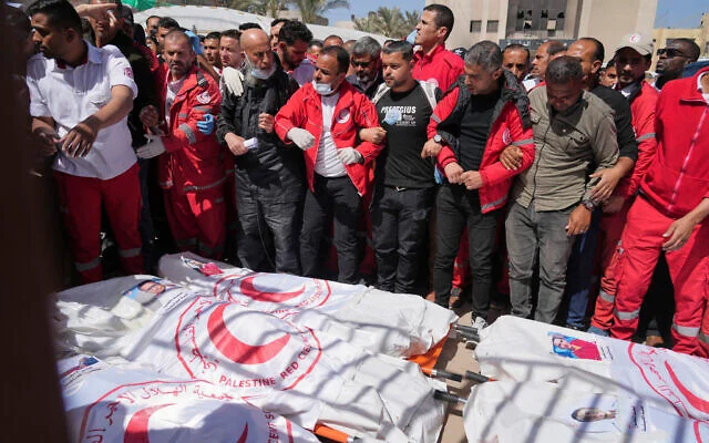 Des personnes en deuil se rassemblent autour des corps de 8 secouristes de la Croix-Rouge, retrouvés à Rafah, dans la bande de Gaza, le 31 mars 2025. (Crédit : AP Photo/ Abdel Kareem Hana) Des personnes en deuil se rassemblent autour des corps de 8 secouristes de la Croix-Rouge, retrouvés à Rafah, dans la bande de Gaza, le 31 mars 2025. (Crédit : AP Photo/ Abdel Kareem Hana)