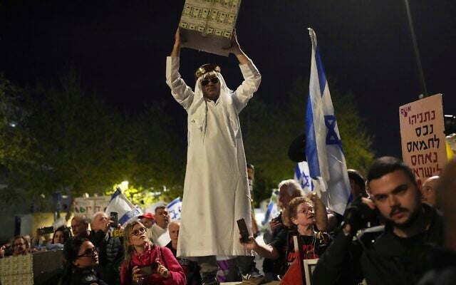 Des personnes manifestant contre le gouvernement du Premier ministre Benjamin Netanyahu, devant la Knesset, à Jérusalem, le 31 mars 2025. (Crédit : Ohad Zwigenberg/AP) Des personnes manifestant contre le gouvernement du Premier ministre Benjamin Netanyahu, devant la Knesset, à Jérusalem, le 31 mars 2025. (Crédit : Ohad Zwigenberg/AP)