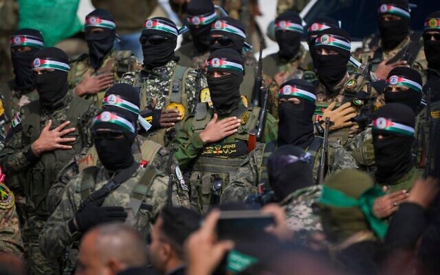 Des terroristes du Hamas se tenant en formation avant une cérémonie de remise d'otages israéliens à la Croix-Rouge, à Nuseirat, dans le centre de la bande de Gaza, le 22 février 2025. (Crédit : Abdel Kareem Hana/AP) Des terroristes du Hamas se tenant en formation avant une cérémonie de remise d'otages israéliens à la Croix-Rouge, à Nuseirat, dans le centre de la bande de Gaza, le 22 février 2025. (Crédit : Abdel Kareem Hana/AP)