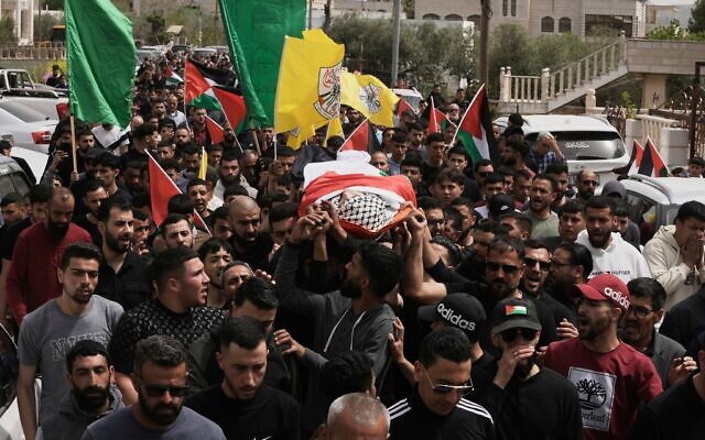Des personnes en deuil portant Omar Mohammad Rabea, un Palestino-Américain de 14 ans abattu par des soldats israéliens, lors de ses funérailles, dans la ville de Turmus Ayya, en Cisjordanie, le 7 avril 2025. (Crédit : Mahmoud Illean/AP) Des personnes en deuil portant Omar Mohammad Rabea, un Palestino-Américain de 14 ans abattu par des soldats israéliens, lors de ses funérailles, dans la ville de Turmus Ayya, en Cisjordanie, le 7 avril 2025. (Crédit : Mahmoud Illean/AP)