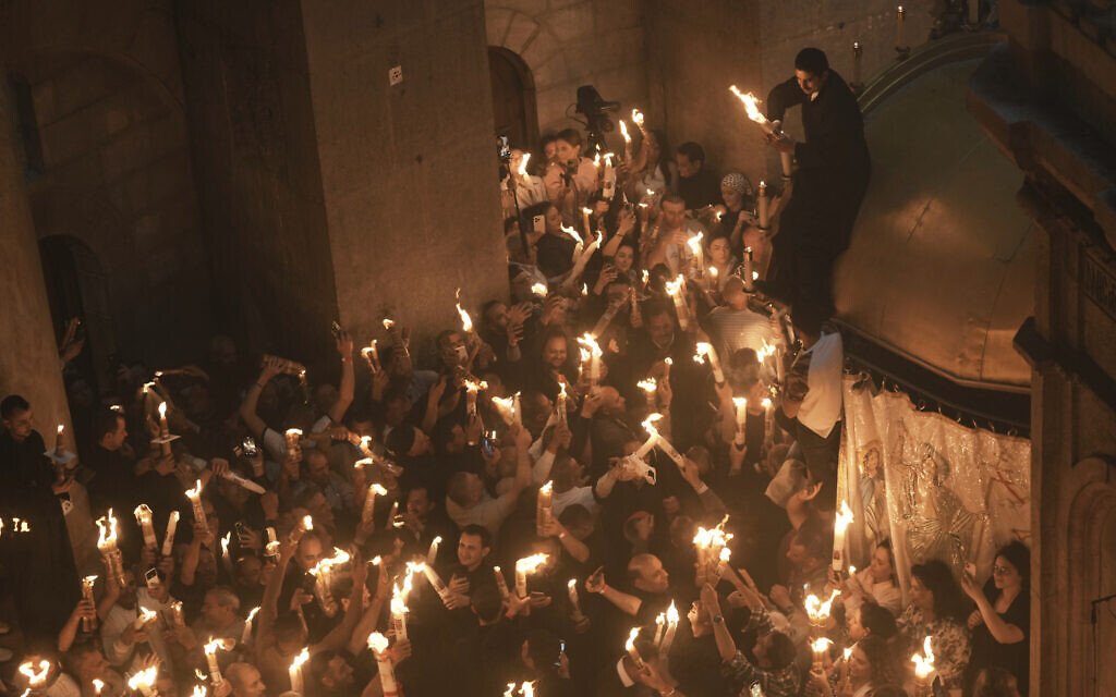 Les pèlerins chrétiens allument des bougies lors de la cérémonie du feu sacré dans l'église du Saint-Sépulcre, le site où, selon la tradition, Jésus a été crucifié et enterré, dans la Vieille ville de Jérusalem, le samedi 19 avril 2025. (Crédit : AP Photo/Mahmoud Illean)