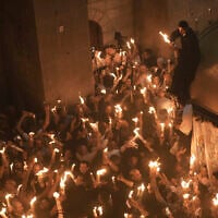 Les pèlerins chrétiens allument des bougies lors de la cérémonie du feu sacré dans l'église du Saint-Sépulcre, le site où, selon la tradition, Jésus a été crucifié et enterré, dans la Vieille ville de Jérusalem, le samedi 19 avril 2025. (Crédit : AP Photo/Mahmoud Illean)