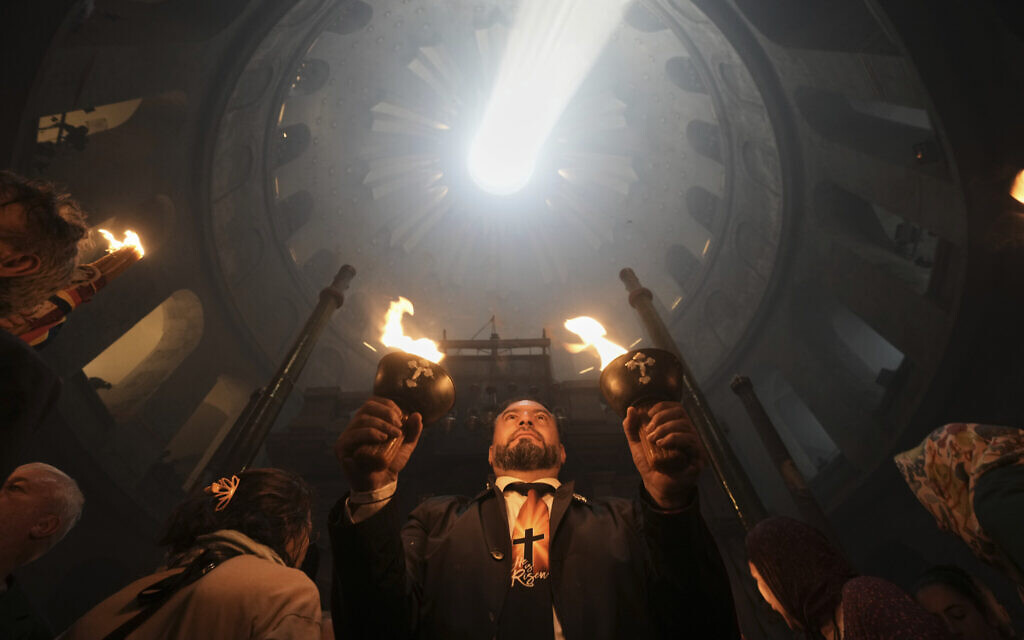 Les pèlerins chrétiens tiennent des bougies lors de la cérémonie du feu sacré dans l'église du Saint-Sépulcre, le site où, selon la tradition, Jésus a été crucifié et enterré, dans la Vieille ville de Jérusalem, le samedi 19 avril 2025. (Crédit : AP Photo/Mahmoud Illean)