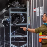 Des sacs contenant les restes humains des  victimes du pogrom du Hamas, le 7 octobre 2023, sont empilés dans un conteneur à la base militaire de Shura, près de Ramle, le 24 octobre 2023. (Crédit : Yossi Aloni/Flash90)