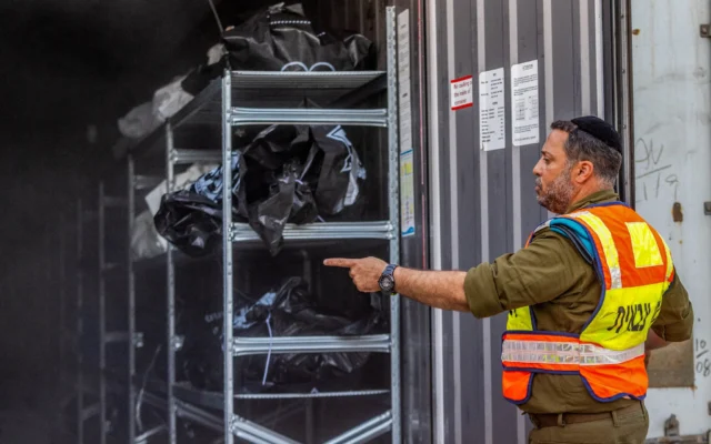 Des sacs contenant les restes humains des  victimes du pogrom du Hamas, le 7 octobre 2023, sont empilés dans un conteneur à la base militaire de Shura, près de Ramle, le 24 octobre 2023. (Crédit : Yossi Aloni/Flash90)