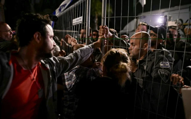 Des personnes protestent contre le Premier ministre Benjamin Netanyahu avant sa visite à une célébration à Moshav Mazor, le 19 avril 2025. (Crédit : Tomer Neuberg/Flash90)