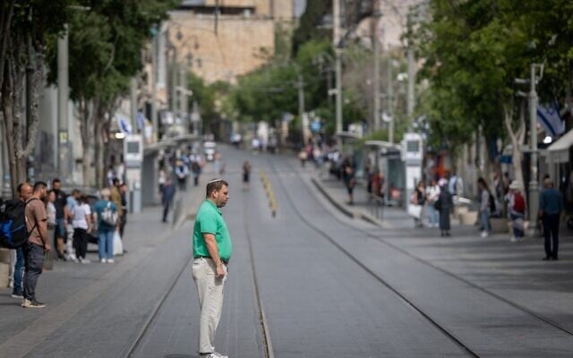 Les gens immobiles alors qu'une sirène retentit pendant deux minutes dans tout Israël pour marquer Yom HaShoah, à Jérusalem, le 24 avril 2025. (Crédit : Chaïm Goldberg/Flash90)