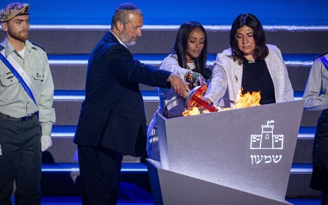 Le rabbin Shmuel Slotki, Racheli Tadesa Malkai et Riki Sitton allumant un flambeau lors d'une répétition pour la cérémonie de la 77ᵉ fête de l'indépendance, sur le mont Herzl, à Jérusalem, le 28 avril 2025. (Crédit : Yonatan Sindel/Flash90)