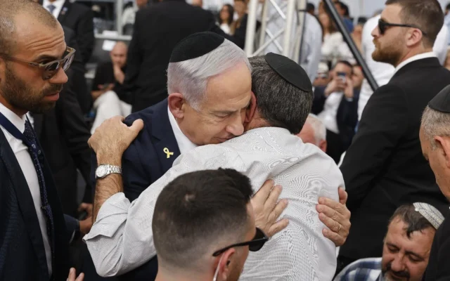 Le Premier ministre Benjamin Netanyahu s'entretient avec un parent endeuillé lors d'une cérémonie organisée à la veille de Yom HaZikaron à Yad Labanim, à Jérusalem, le 29 avril 2025. (Crédit : Olivier Fitoussi/POOL)