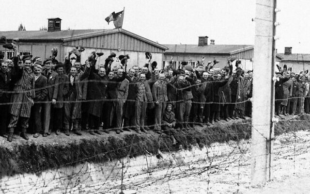 Sur cette photo non datée, des prisonniers se pressent contre la clôture électrique du camp de concentration de Dachau, en Allemagne, pour saluer l'arrivée des Américains. (Crédit : AP/File) Sur cette photo non datée, des prisonniers se pressent contre la clôture électrique du camp de concentration de Dachau, en Allemagne, pour saluer l'arrivée des Américains. (Crédit : AP/File)