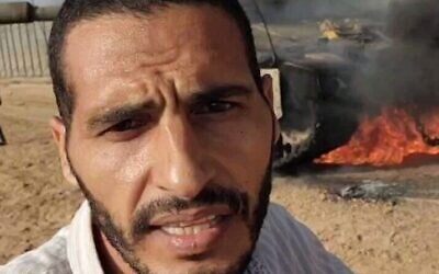 Le journaliste et terroriste présumé du Hamas Hassan Eslaiah devant un char de l’armée israélienne en feu lors du pogrom perpétré par le Hamas, le 7 octobre 2023. (Crédit : Capture d'écran/X ; utilisée conformément à l'article 27a de la loi sur le droit d'auteur)