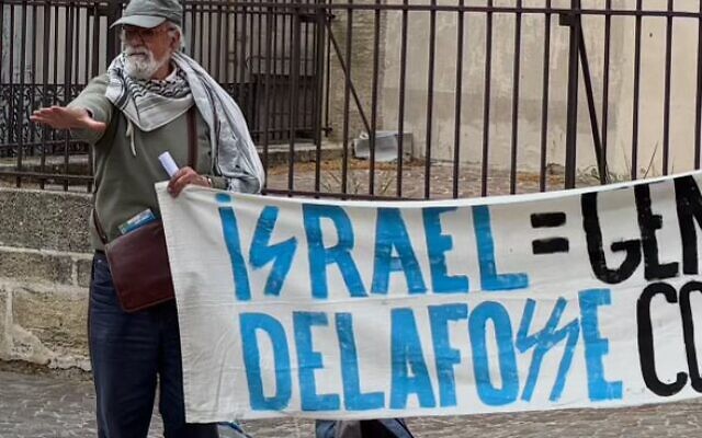 Un militant du collectif BDS Montpellier tient une banderole utilisant une typographie nazie dans le nom d'Israël et du maire de la ville, Michaël Delafosse, sur une photo non datée partagée sur les réseaux sociaux par le maire le 11 avril 2025. (Crédit : X / @MDelafosse / utilisée conformément à l'article 27a de la loi sur le droit d'auteur) Un militant du collectif BDS Montpellier tient une banderole utilisant une typographie nazie dans le nom d'Israël et du maire de la ville, Michaël Delafosse, sur une photo non datée partagée sur les réseaux sociaux par le maire le 11 avril 2025. (Crédit : X / @MDelafosse / utilisée conformément à l'article 27a de la loi sur le droit d'auteur)