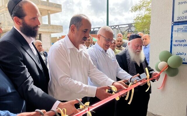 Le maire de Mazraa, Fouad Awad (2ᵉ en partant de la gauche), et le ministre du Logement, Yitzhak Goldknopf (tout à droite), lors d'une cérémonie d'inauguration à Mazraa, le 9 avril 2025. (Crédit : Diana Bletter/Times of Israel) Le maire de Mazraa, Fouad Awad (2ᵉ en partant de la gauche), et le ministre du Logement, Yitzhak Goldknopf (tout à droite), lors d'une cérémonie d'inauguration à Mazraa, le 9 avril 2025. (Crédit : Diana Bletter/Times of Israel)