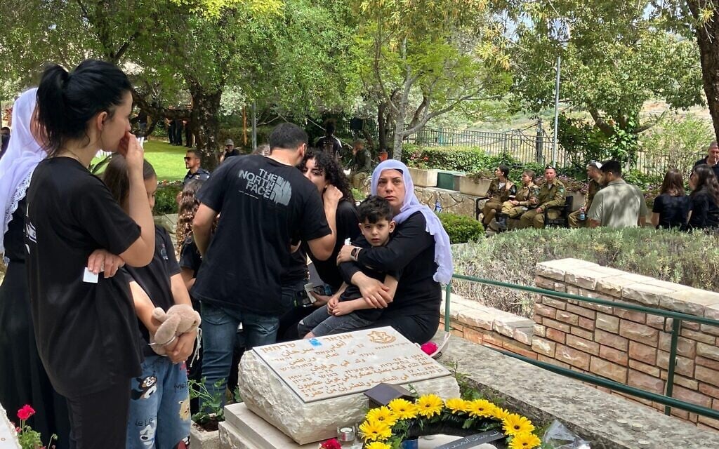 Marwa Gadban, sœur du soldat tué Anwar Serhan, à côté de sa tombe le 30 avril 2025 à Hurfeish. (Diana Bletter/Times of Israel)