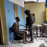 Un soldat de l'armée israélienne se tient debout devant un suspect palestinien à Gaza dans une séquence non datée téléchargée sur les réseaux sociaux le 2 février 2024. (Capture d'écran/X)