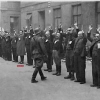 Les troupes allemandes arrêtant les derniers membres survivants du soulèvement du Ghetto de Varsovie, sur cette photo tirée du rapport Stroop. Un trait rouge marque l'emplacement de Michael Smuss, avec son père à sa droite. (Crédit : Collection des Archives nationales des États-Unis sur les crimes de guerre de la Seconde Guerre mondiale)