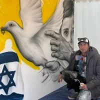 L'artiste israélien Benzi Brofman pose avec sa peinture murale « The Process » lors de la conférence sur l'antisémitisme contemporain qui s'est tenue du 29 mars au 1er avril 2025 dans le centre culturel juif JW3 de la ville. (Crédit : Lakruwan Rajapaksha)