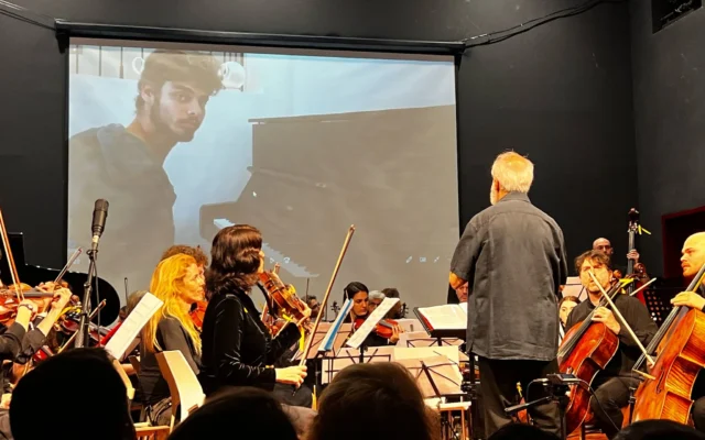 L'Orchestre Lu Yehi accompagnant une vidéo d'Alon Ohel jouant du piano, avant qu'il ne soit fait otage, à Jérusalem, le 8 avril 2025. (Crédit : Autorisation)