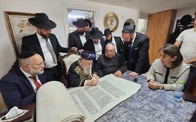 Le Grand Rabbin Yitzhak Yosef participe à l'écriture d'un rouleau de Torah dédié au sergent Segev Schwartz, 20 ans, tué au combat le 7 octobre 2023, avant Yom HaZikaron 2025. (Crédit : Ayelet HaShachar)