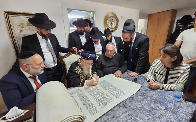 Le Grand Rabbin Yitzhak Yosef participe à l'écriture d'un rouleau de Torah dédié au sergent Segev Schwartz, 20 ans, tué au combat le 7 octobre 2023, avant Yom HaZikaron 2025. (Crédit : Ayelet HaShachar)