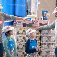 Les copropriétaires de Streit, Aaron Gross (à l'extrême gauche) et Aron Yagoda (à l'extrême droite), faisant visiter l'usine de matzot à deux jeunes invités. (Crédit : Streit via JTA)