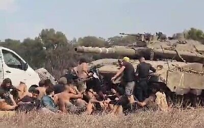 Des participants au festival Nova et des policiers cachés derrière un tank près du site du festival, le 7 octobre 2023. (Crédit : South First Responders)