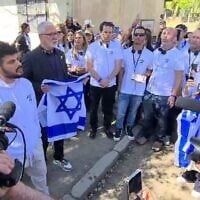 Daniel Weiss, survivant du kibboutz Beeri, chante avec des membres de sa famille sous le portail d'entrée d'Auschwitz, le 23 avril 2025. (Autorisation)