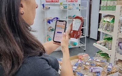 Yaelle Ifrah, la fondatrice de l'application Kaspenu scanne une bouteille de ketchup dans un supermarché à Tel Aviv. (Crédit : Alexandra Vardi)