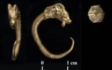 Une boucle d'oreille et une perle de la période hellénistique découvertes dans la Cité de David. (Crédit : Clara Amit, Autorité des antiquités d'Israël)