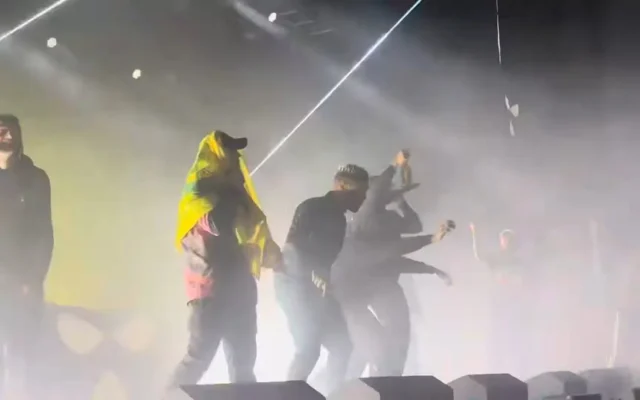 Un membre du groupe irlandais Kneecap porte un drapeau du Hezbollah lors d'un concert à Londres le 21 novembre 2024. (Capture d'écran/YouTube)