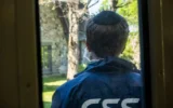 Un bénévole du CSS monte la garde devant une synagogue lors d'un exercice de formation à la sécurité dans le comté de Westchester, dans l'État de New York, le 28 avril 2025. (Crédit : Luke Tress/Times of Israel)