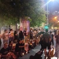 Des manifestants de gauche brandissant des bougies et des photos d'enfants de Gaza qui auraient été tués par Israël, à Tel Aviv, 17 mai 2025. (Crédit : Noam Lehmann/Times of Israel)