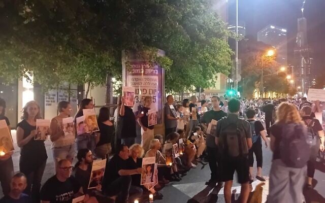 Des manifestants de gauche brandissant des bougies et des photos d'enfants de Gaza qui auraient été tués par Israël, à Tel Aviv, 17 mai 2025. (Crédit : Noam Lehmann/Times of Israel)