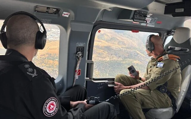 Le chef des services d'incendie et de secours, Eyal Caspi (à gauche), et le chef du commandement du front intérieur, le général de division Rafi Milo, évaluent les incendies à l'extérieur de Jérusalem par hélicoptère, le 1er mai 2025. (Crédit : armée israélienne) Le chef des services d'incendie et de secours, Eyal Caspi (à gauche), et le chef du commandement du front intérieur, le général de division Rafi Milo, évaluent les incendies à l'extérieur de Jérusalem par hélicoptère, le 1er mai 2025. (Crédit : armée israélienne)