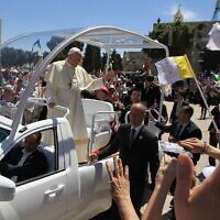 Le pape François saluant la foule depuis sa papamobile à son arrivée sur la Place de la Mangeuse, devant l'Église de la Nativité, dans la ville de Bethléem, en Cisjordanie, le 25 mai 2014. (Crédit : Abbas Momani/AFP)