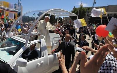 Le pape François saluant la foule depuis sa papamobile à son arrivée sur la Place de la Mangeuse, devant l'Église de la Nativité, dans la ville de Bethléem, en Cisjordanie, le 25 mai 2014. (Crédit : Abbas Momani/AFP)