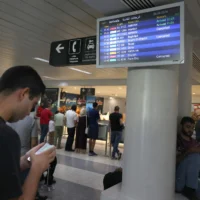 Des passagers vérifient l'heure de leur vol à l'aéroport international de Beyrouth, le 25 août 2024. (Crédit : ANWAR AMRO / AFP)