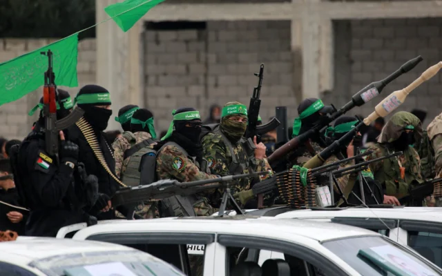 Des terroristes du Hamas avec leurs armes à Nuseirat, dans le centre de la bande de Gaza, avant la libération d'otages israéliens, le 22 février 2025. (Crédit : Bachar Taleb/AFP)