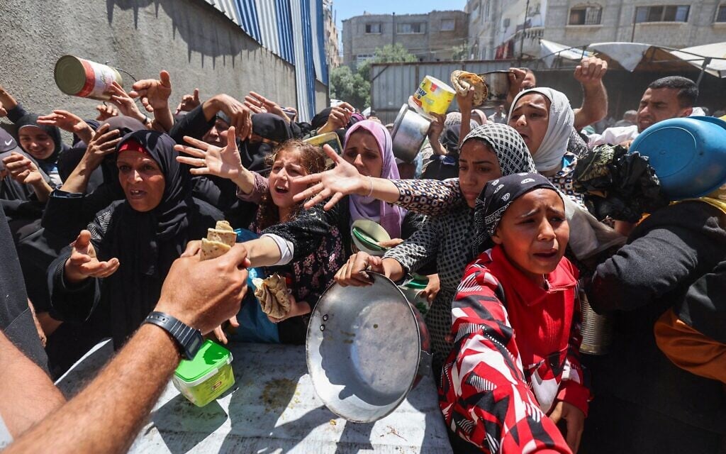 Des Palestiniens font la queue pour un repas chaud dans une cuisine communautaire gérée par le Programme alimentaire mondial (PAM) des Nations Unies dans le camp de réfugiés de Nuseirat, dans le centre de la bande de Gaza, le 26 avril 2025 (Crédit : Eyad BABA / AFP). Des Palestiniens font la queue pour un repas chaud dans une cuisine communautaire gérée par le Programme alimentaire mondial (PAM) des Nations Unies dans le camp de réfugiés de Nuseirat, dans le centre de la bande de Gaza, le 26 avril 2025 (Crédit : Eyad BABA / AFP).