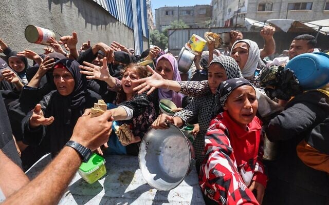 Des Palestiniens font la queue pour un repas chaud dans une cuisine communautaire gérée par le Programme alimentaire mondial (PAM) des Nations Unies dans le camp de réfugiés de Nuseirat, dans le centre de la bande de Gaza, le 26 avril 2025 (Crédit : Eyad BABA / AFP).