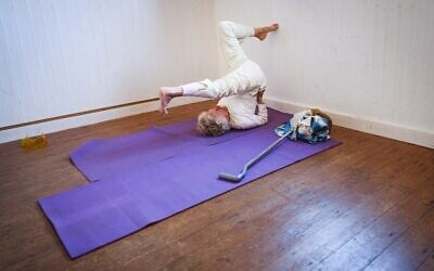 Dorothea Barron, centenaire, s'étire lors d'un cours de yoga à la salle des fêtes près de chez elle, le 31 mars 2025. (Crédit : Adrian DENNIS / AFP)