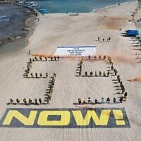 Des plongeurs réalisent une installation appelant à la libération des otages israéliens détenus dans la bande de Gaza, le 1er mai 2025 sur la plage de Césarée. (Crédit : JACK GUEZ / AFP)