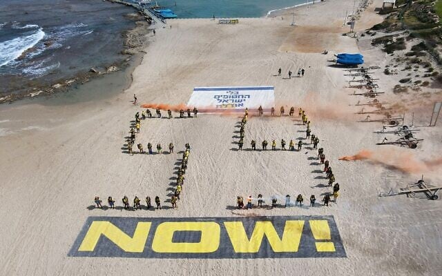 Des plongeurs réalisent une installation appelant à la libération des otages israéliens détenus dans la bande de Gaza, le 1er mai 2025 sur la plage de Césarée. (Crédit : JACK GUEZ / AFP)