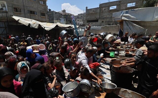 Des Palestiniens faisant la queue pour recevoir un repas chaud dans une cuisine caritative dans le camp de Nuseirat, dans le centre de la bande de Gaza, le 4 mai 2025. (Crédit : Eyad Baba/AFP) Des Palestiniens faisant la queue pour recevoir un repas chaud dans une cuisine caritative dans le camp de Nuseirat, dans le centre de la bande de Gaza, le 4 mai 2025. (Crédit : Eyad Baba/AFP)
