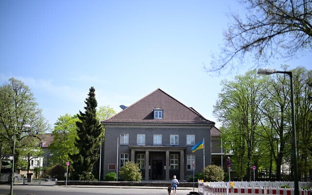 Un drapeau ukrainien flotte le 17 avril 2025 devant le musée de Berlin-Karlshorst, le site où, dans la nuit du 8 au 9 mai 1945, les commandants suprêmes de la Wehrmacht ont signé la capitulation sans condition devant les représentants de l'Union soviétique, des États-Unis, de la Grande-Bretagne et de la France. Alors que l'Allemagne célèbre les 80 ans de la fin de la Seconde Guerre mondiale, un site historique de Berlin s'interroge sur la manière de commémorer le rôle des Soviétiques dans la défaite du nazisme, dans le contexte de l'invasion de l'Ukraine par la Russie. À Karlshorst, un quartier verdoyant de l'ancien Berlin-Est, se dresse l'imposant bâtiment où, dans la nuit du 8 mai 1945, les nazis ont officiellement capitulé devant les Alliés victorieux, y compris l'Armée rouge.  (Crédit : Tobias Schwarz / AFP)