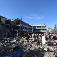 Des Palestiniens passent au crible des débris après une frappe israélienne dans le camp de réfugiés de Bureij, au centre de la bande de Gaza, le 7 mai 2025. (Crédit : Eyad BABA / AFP)